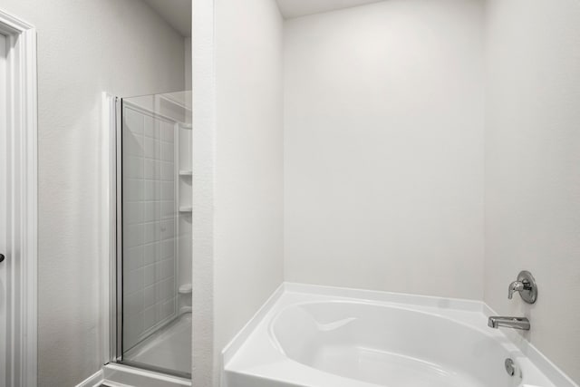 bathroom with a shower with door and a washtub