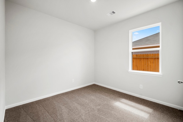 spare room with visible vents, baseboards, and carpet flooring