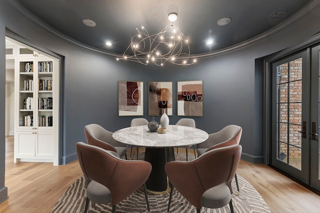 dining space with french doors, wood finished floors, baseboards, and ornamental molding