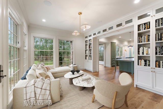 living area with crown molding, baseboards, built in features, recessed lighting, and light wood-style floors