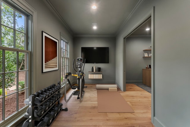 exercise area with recessed lighting, baseboards, crown molding, and light wood finished floors