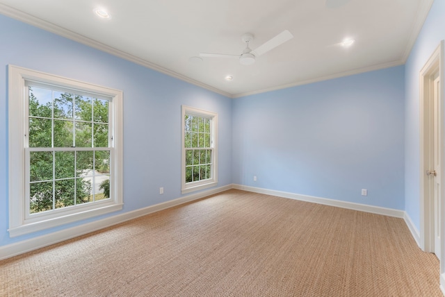 unfurnished room with ceiling fan, light colored carpet, baseboards, and ornamental molding