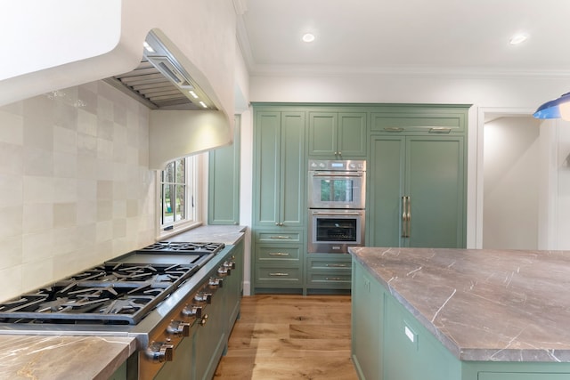 kitchen with light wood-type flooring, stainless steel appliances, green cabinets, and ornamental molding