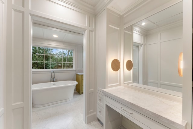 bathroom with a freestanding tub, marble finish floor, ornamental molding, recessed lighting, and a decorative wall