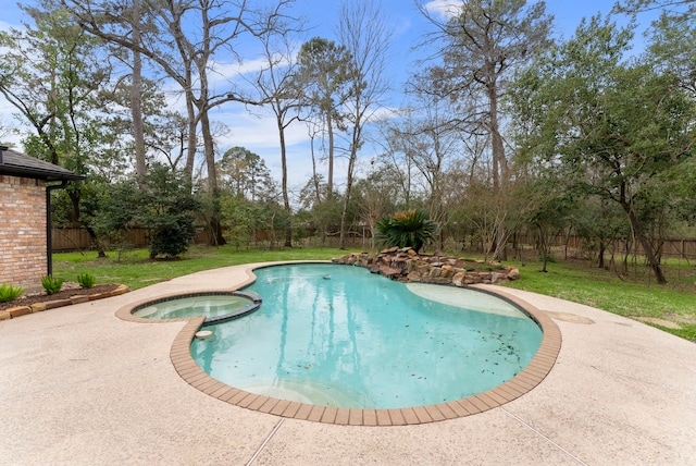 view of pool with a pool with connected hot tub, a yard, and fence