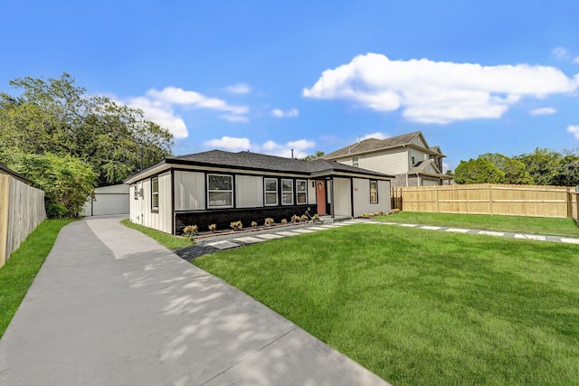 view of front of property featuring brick siding, board and batten siding, fence, a front yard, and a garage