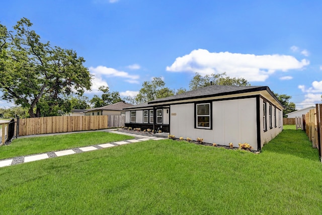 back of house featuring a lawn and a fenced backyard