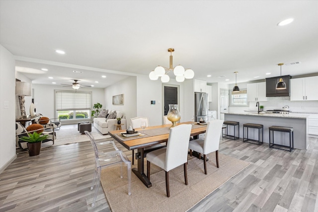 dining space featuring ceiling fan with notable chandelier, recessed lighting, visible vents, and light wood finished floors