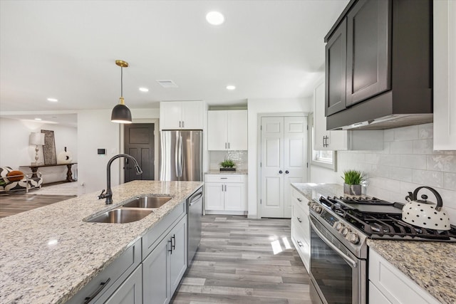 kitchen with a sink, stainless steel appliances, light wood-style flooring, and recessed lighting