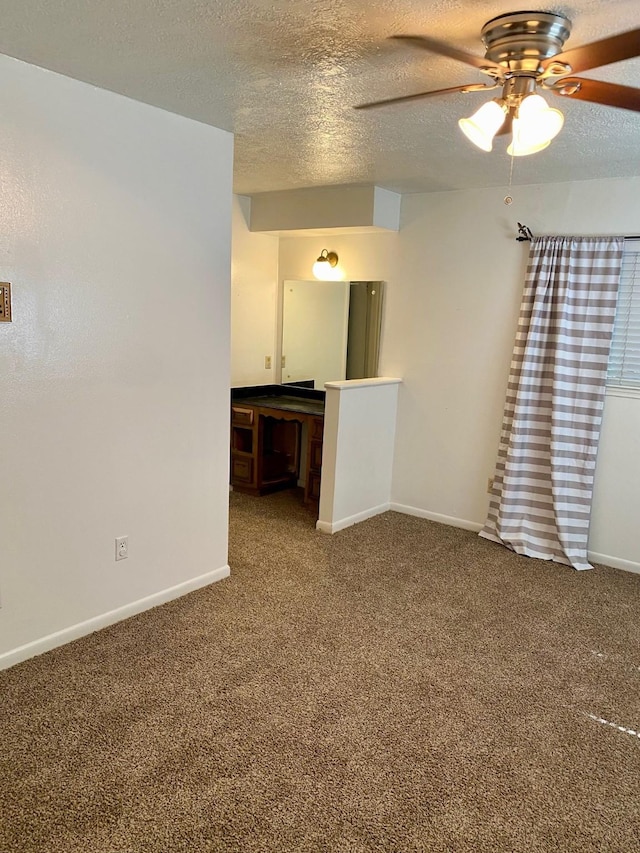 unfurnished living room featuring carpet flooring, baseboards, and a textured ceiling