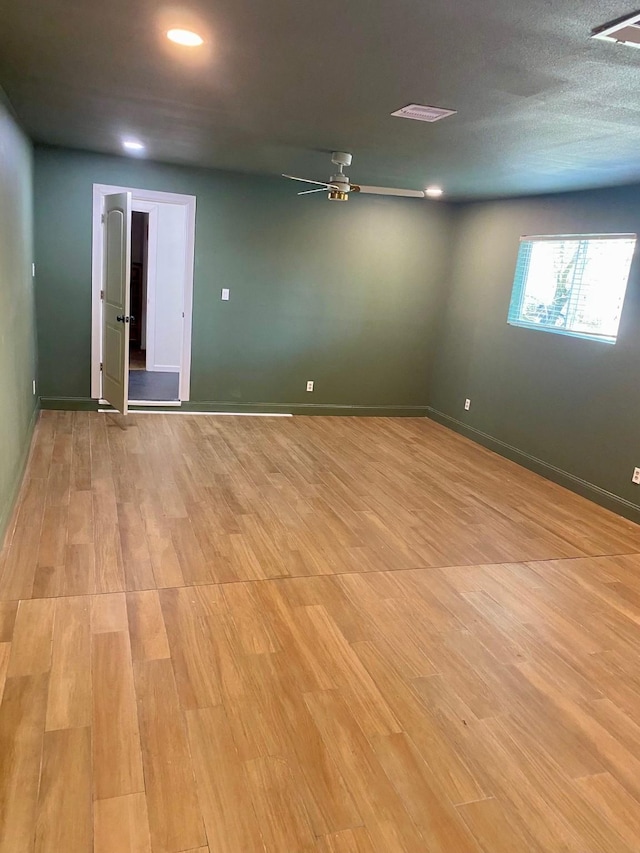 unfurnished room featuring baseboards, light wood-type flooring, and ceiling fan