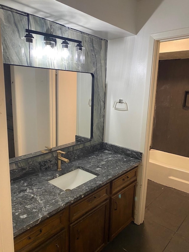 bathroom featuring a tub, vanity, and tile patterned flooring