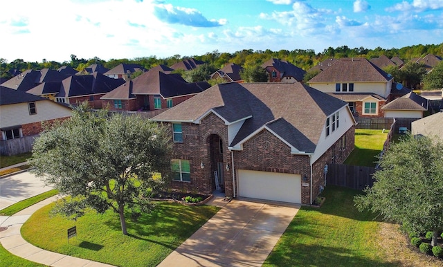 view of front of home featuring a front yard, fence, brick siding, and a residential view