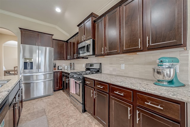 kitchen with light stone countertops, arched walkways, ornamental molding, decorative backsplash, and appliances with stainless steel finishes