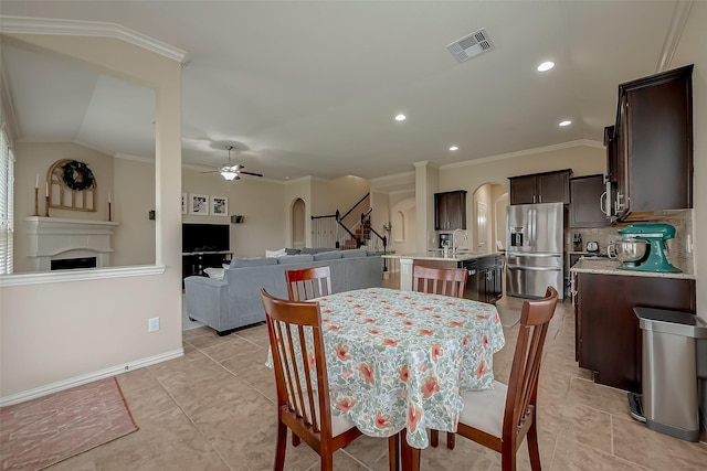 dining space with visible vents, crown molding, recessed lighting, arched walkways, and a ceiling fan