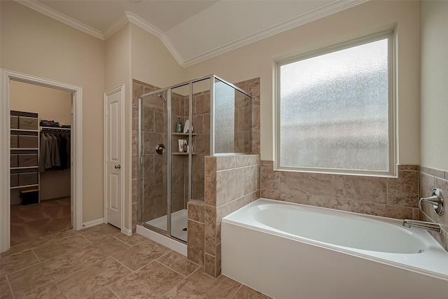 bathroom featuring a walk in closet, crown molding, a bath, and a stall shower