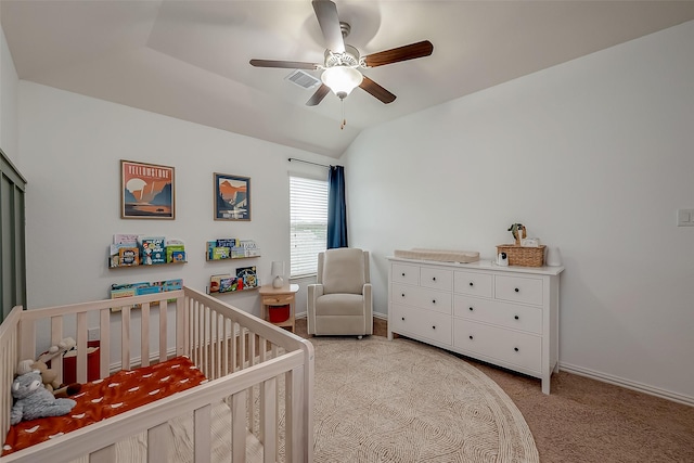 carpeted bedroom featuring baseboards, visible vents, ceiling fan, a crib, and vaulted ceiling