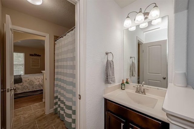 full bath featuring tile patterned flooring, a textured ceiling, and vanity