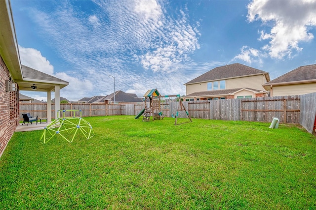 view of yard with a patio, a playground, and a fenced backyard