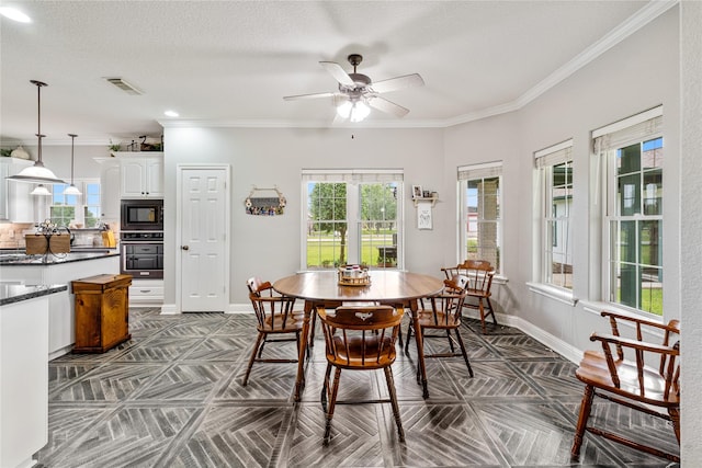 dining room with visible vents, baseboards, ornamental molding, and a ceiling fan