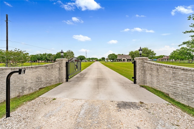 view of gate with a lawn and fence