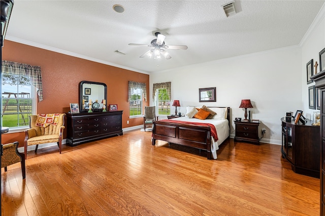 bedroom with multiple windows, crown molding, and light wood-type flooring