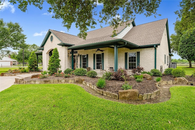 view of front of home featuring brick siding, a shingled roof, a porch, a front yard, and a ceiling fan