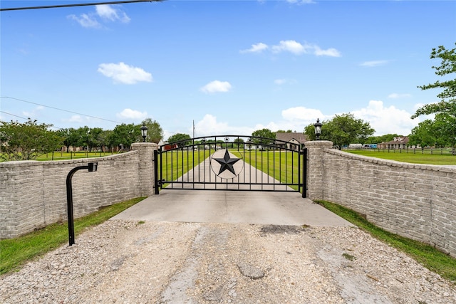 view of gate featuring a yard and fence