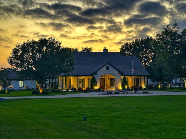 french country home with a yard and a chimney