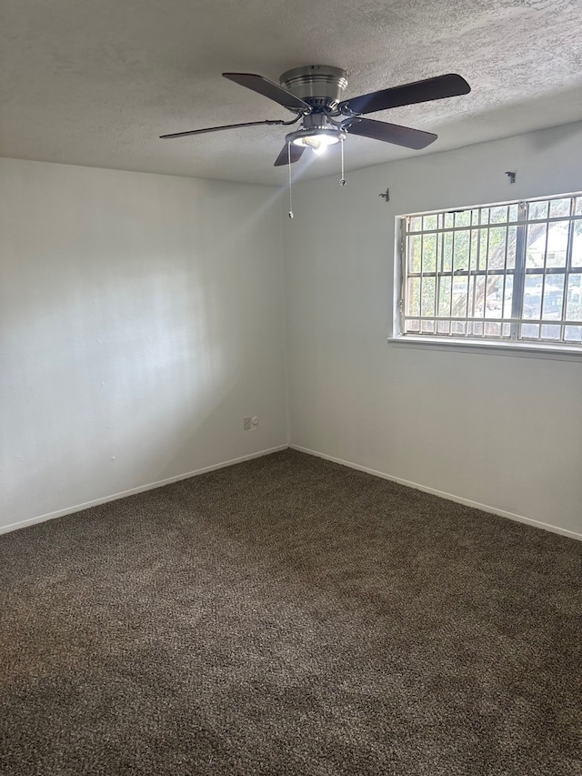 carpeted spare room with baseboards and a textured ceiling