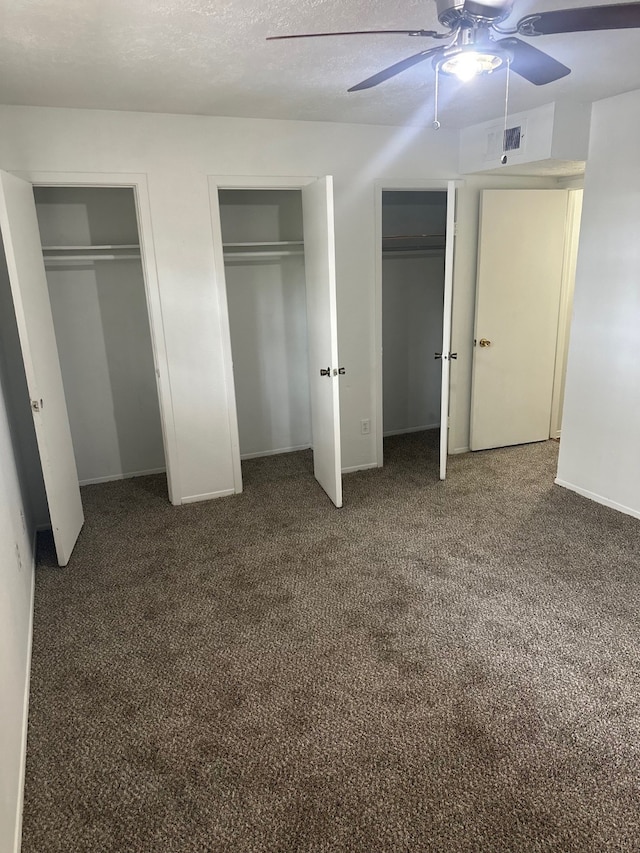 unfurnished bedroom with carpet, visible vents, baseboards, multiple closets, and a textured ceiling