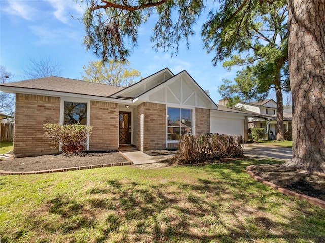 view of front of home featuring brick siding, an attached garage, and a front lawn