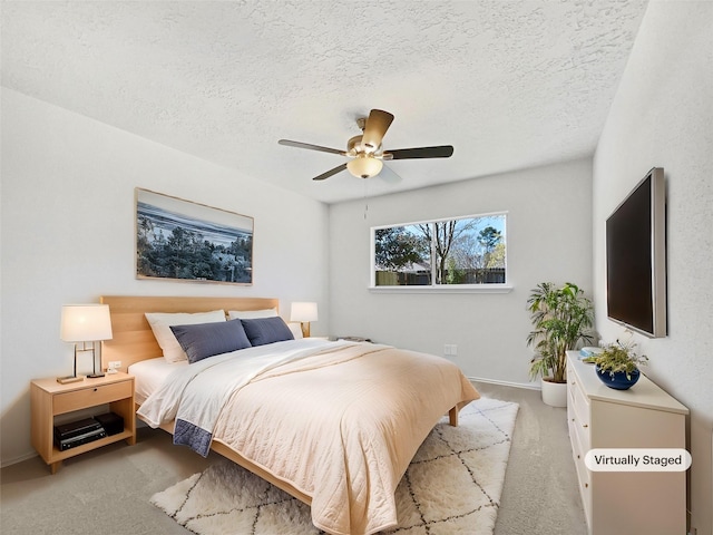 bedroom with a ceiling fan, carpet floors, and a textured ceiling