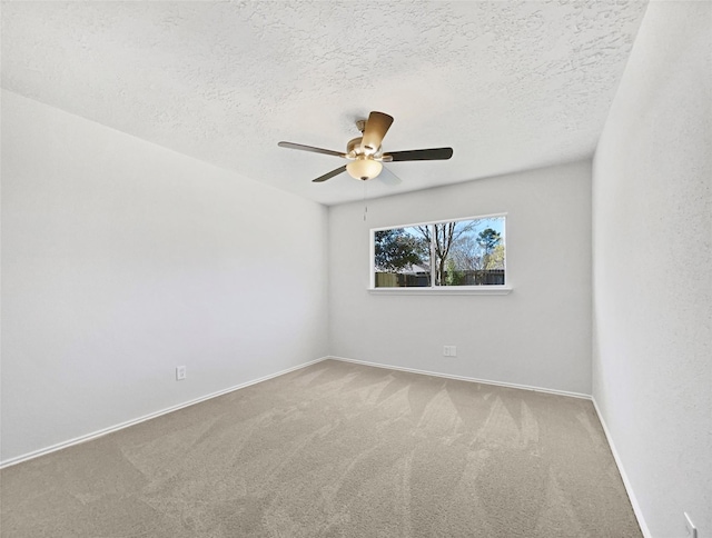 empty room featuring a textured ceiling, a ceiling fan, baseboards, and carpet floors