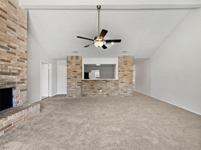 unfurnished living room featuring carpet flooring, a fireplace, lofted ceiling with beams, and a ceiling fan