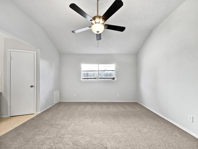 empty room featuring carpet, baseboards, visible vents, ceiling fan, and tile patterned flooring