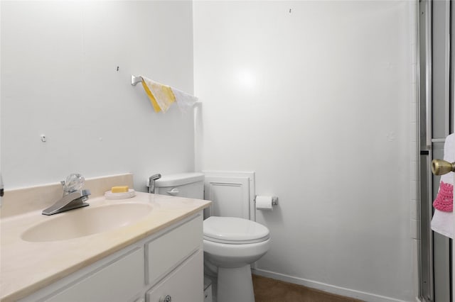 bathroom featuring baseboards, toilet, and vanity