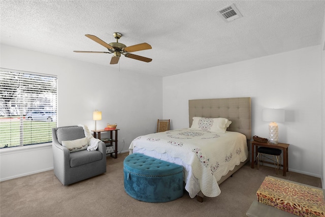 bedroom with visible vents, a textured ceiling, carpet, baseboards, and ceiling fan