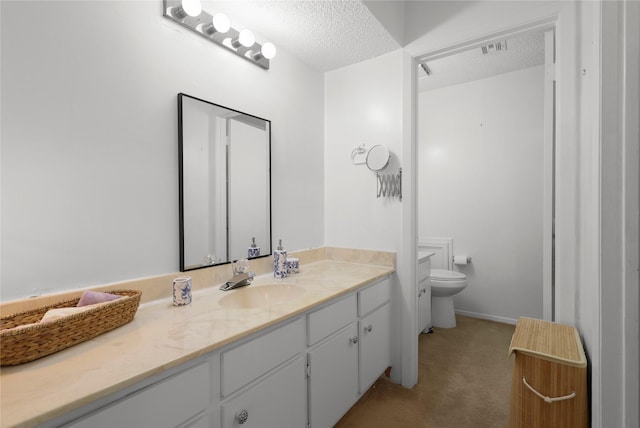 bathroom featuring vanity, toilet, visible vents, and a textured ceiling