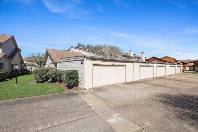 view of side of property with community garages and a yard