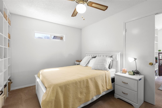 bedroom with ceiling fan, baseboards, dark carpet, and a textured ceiling