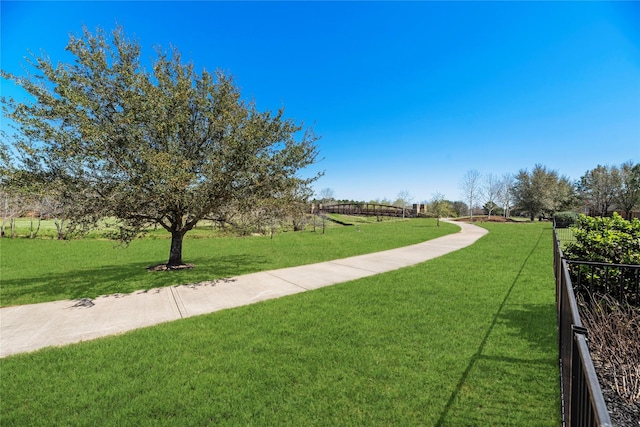 view of community with a yard and fence