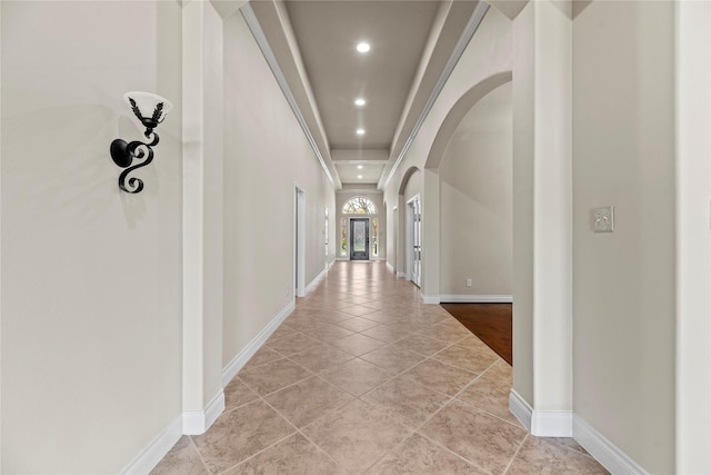 hall with arched walkways, light tile patterned floors, recessed lighting, and baseboards