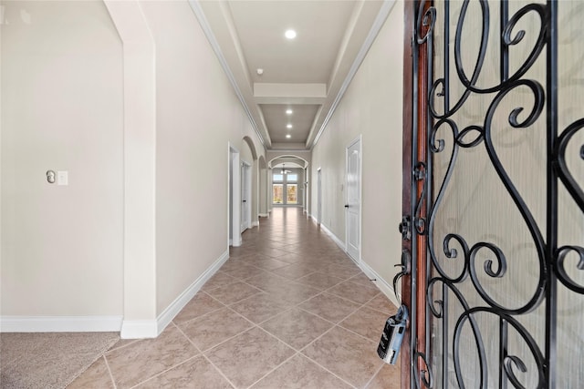 hallway featuring arched walkways, recessed lighting, baseboards, and light tile patterned flooring