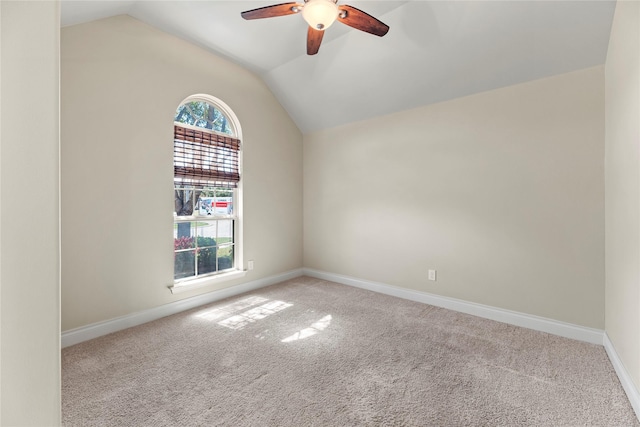 empty room featuring baseboards, lofted ceiling, a ceiling fan, and carpet flooring