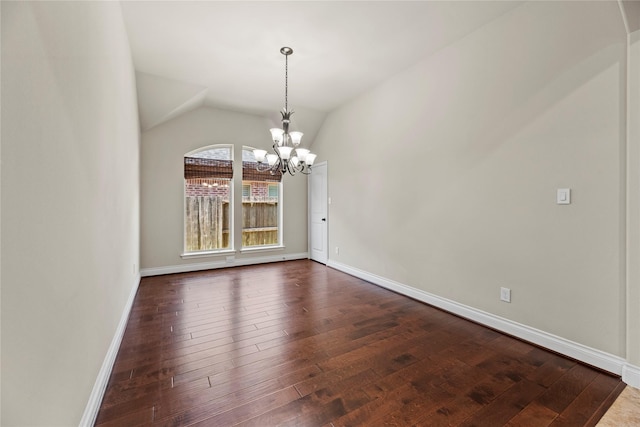 empty room with dark wood finished floors, baseboards, lofted ceiling, and an inviting chandelier