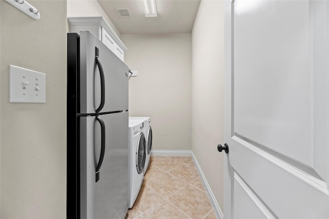 washroom with visible vents, washing machine and dryer, light tile patterned flooring, baseboards, and laundry area