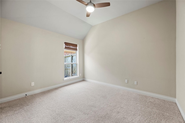 carpeted spare room with vaulted ceiling, baseboards, and ceiling fan