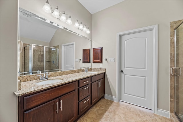 bathroom with double vanity, a stall shower, and a sink