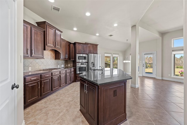 kitchen with a wealth of natural light, visible vents, tasteful backsplash, and appliances with stainless steel finishes